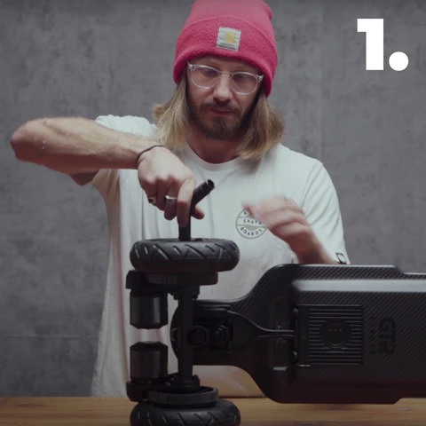 Photo d'un homme en train de démonter les roues d'un e-skate